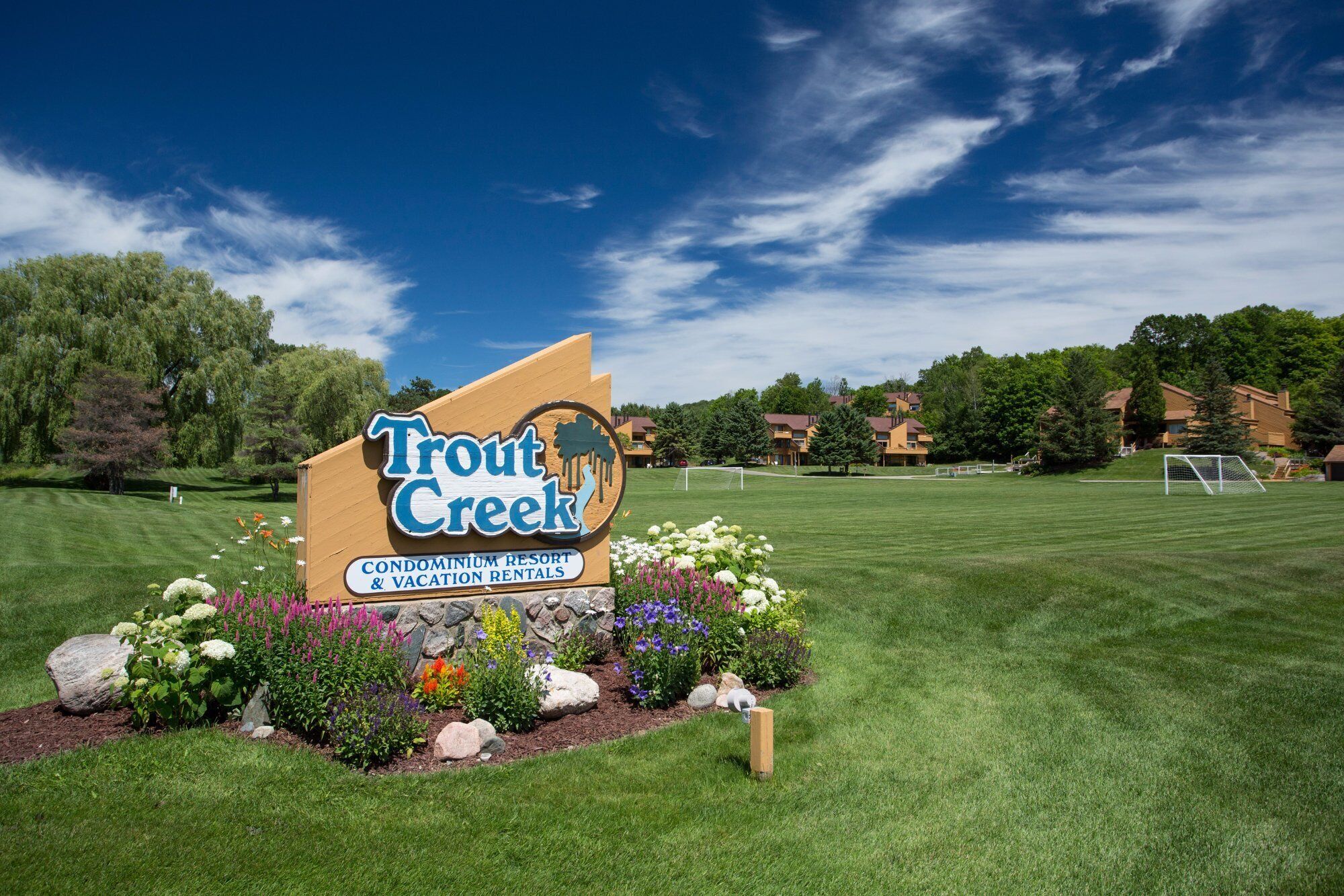 Naamplaatje voor Trout Creek Condominium Resort & Vacation Rentals, met een verzorgd gazon en een voetbalveld.