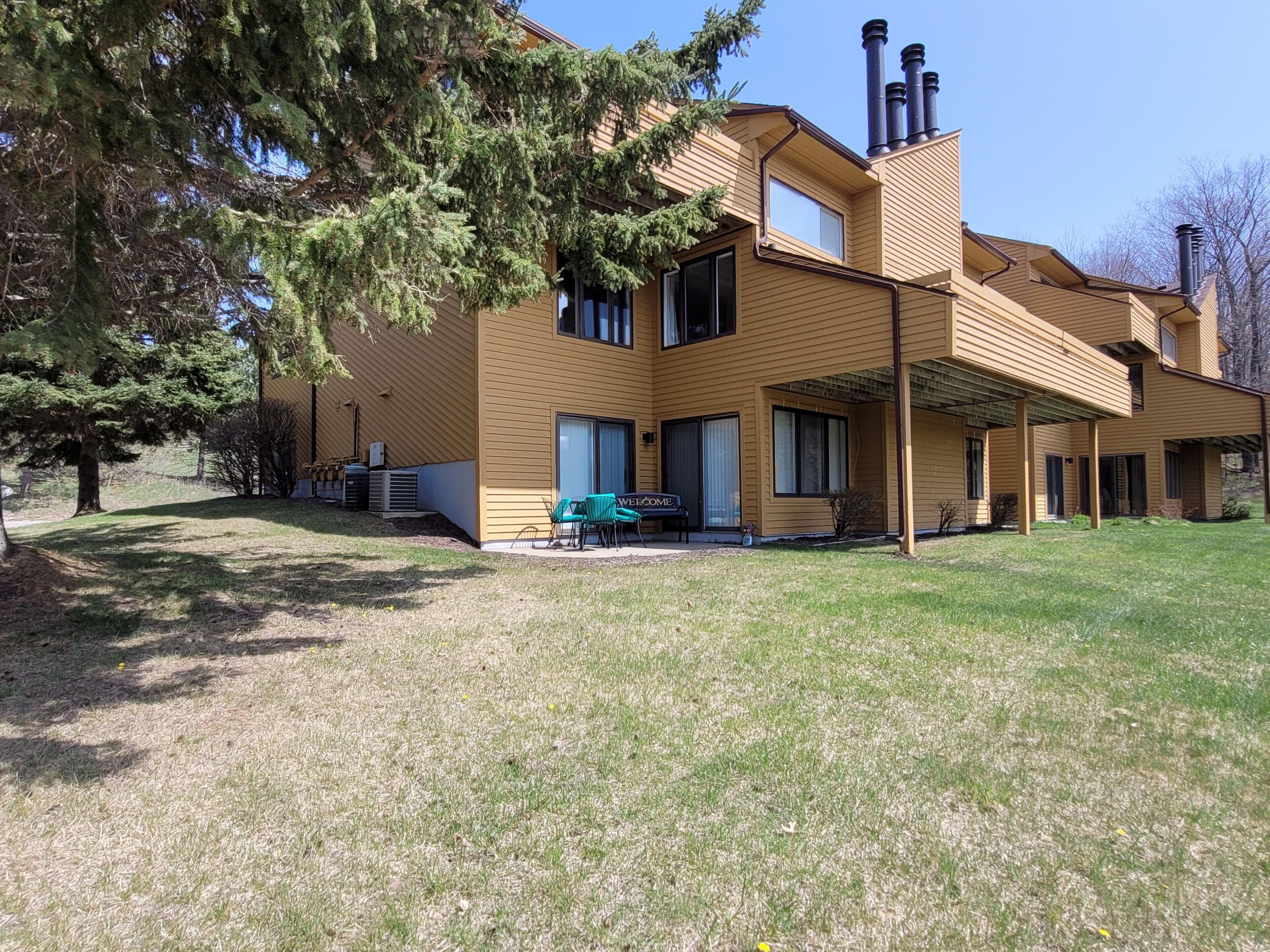 Una casa moderna de dos pisos con un porche cubierto y un césped bien cuidado.