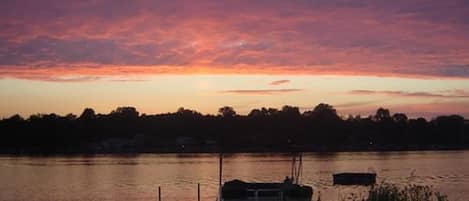 A dock with a boat at sunset.
