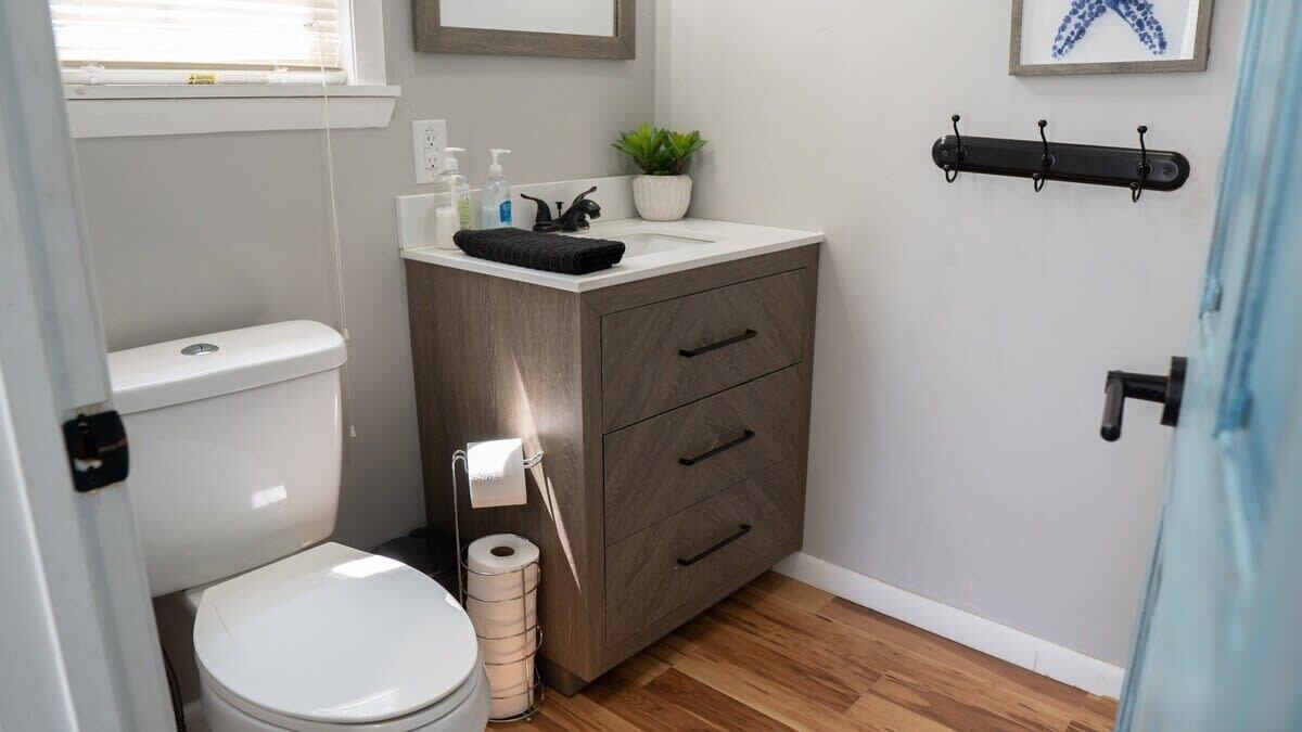 Une petite salle de bain comprenant des toilettes, un lavabo et un meuble de rangement.