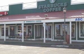 Ein Starbucks Kaffee mit Außenbestuhlung und einem Schild für ABC.