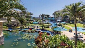 A resort with a large pool area, palm trees, and a view of the ocean. - 2 Bedroom 3 bath in Waipouli Deluxe oceanfront condominium Resort (Kapaa)