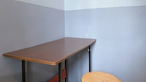 A corner of a room with a wooden table and a round stool. - K Hotel 1515 (Singapore)