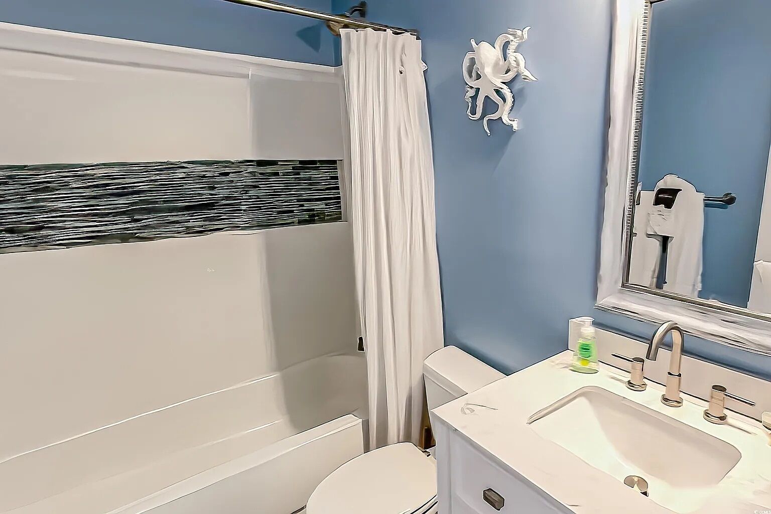 A bathroom with a bathtub, toilet, and sink.