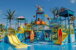 A water park with slides, a wave machine, and a lifeguard tower.