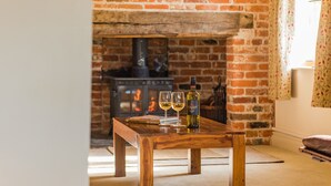 A wooden table with books and wine glasses in a room with a brick fireplace. - The Oast by Bloom Stays - charming oast house in beautiful countryside (Newenden)