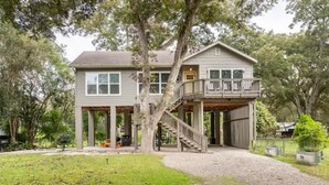 A two-story house with a covered porch and a staircase leading to a second-floor balcony.