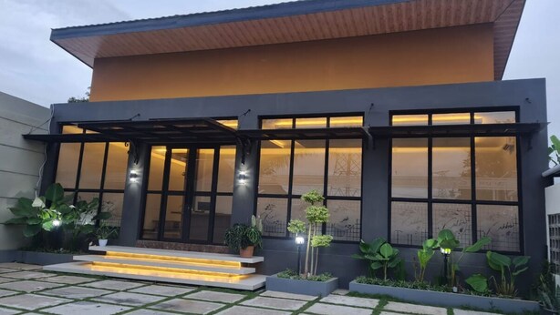 A modern two-story house with large windows, a wooden roof, and a well-lit entrance. - KingKabba Guest House Wonosobo (Wonosobo)