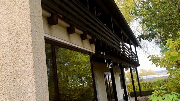 A building with large windows and a covered porch area. - Pension Jägerschenke (Luhe-Wildenau)