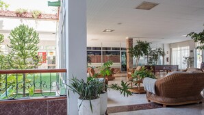 A spacious lobby with a pool table, comfortable seating, and potted plants.