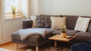 A living room with a sofa, a coffee table, and a painting on the wall. - Alex 12 "Meeresleuchten" 1.O.G.  (Rostock)