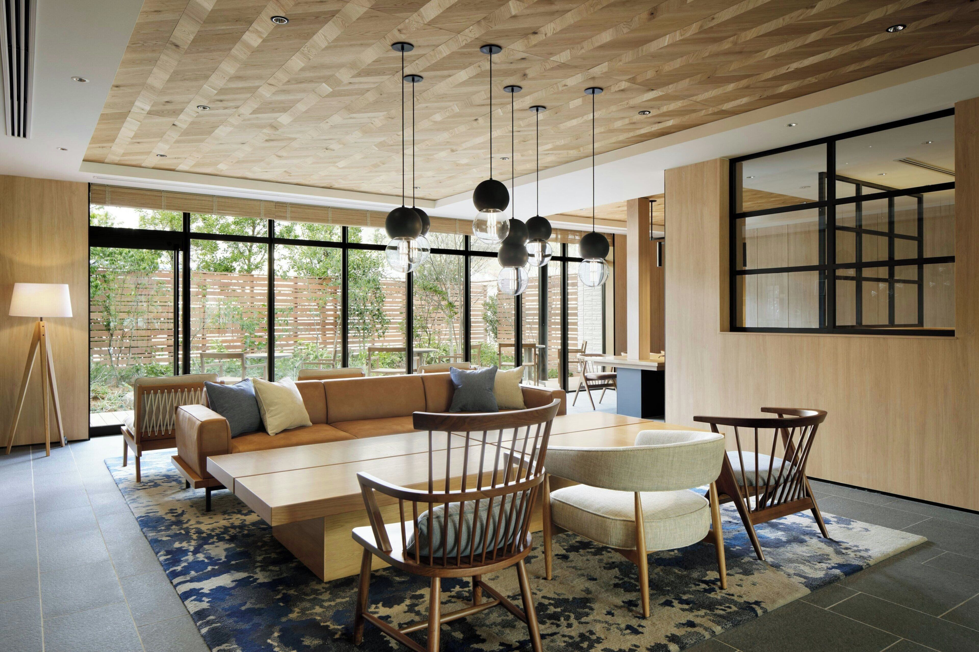 A modern interior with a sectional sofa, dining table, chairs, and pendant lighting.