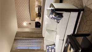 Ein Hotelzimmer mit Bett, Sofa, Couchtisch, Lampe und Nachttisch.