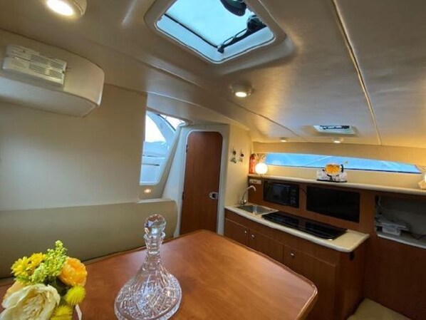 A compact galley with a small sink, a microwave, and a window above the counter.