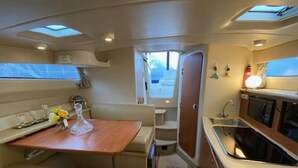A compact kitchen with a sink, microwave, and a small dining area with a table and chairs.