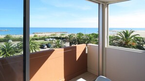 A balcony with a view of the beach and ocean.
