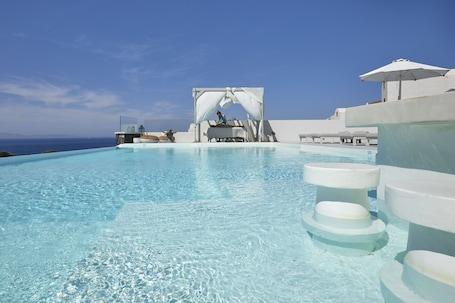 Seasonal outdoor pool, pool umbrellas, sun loungers. Adorno Oia