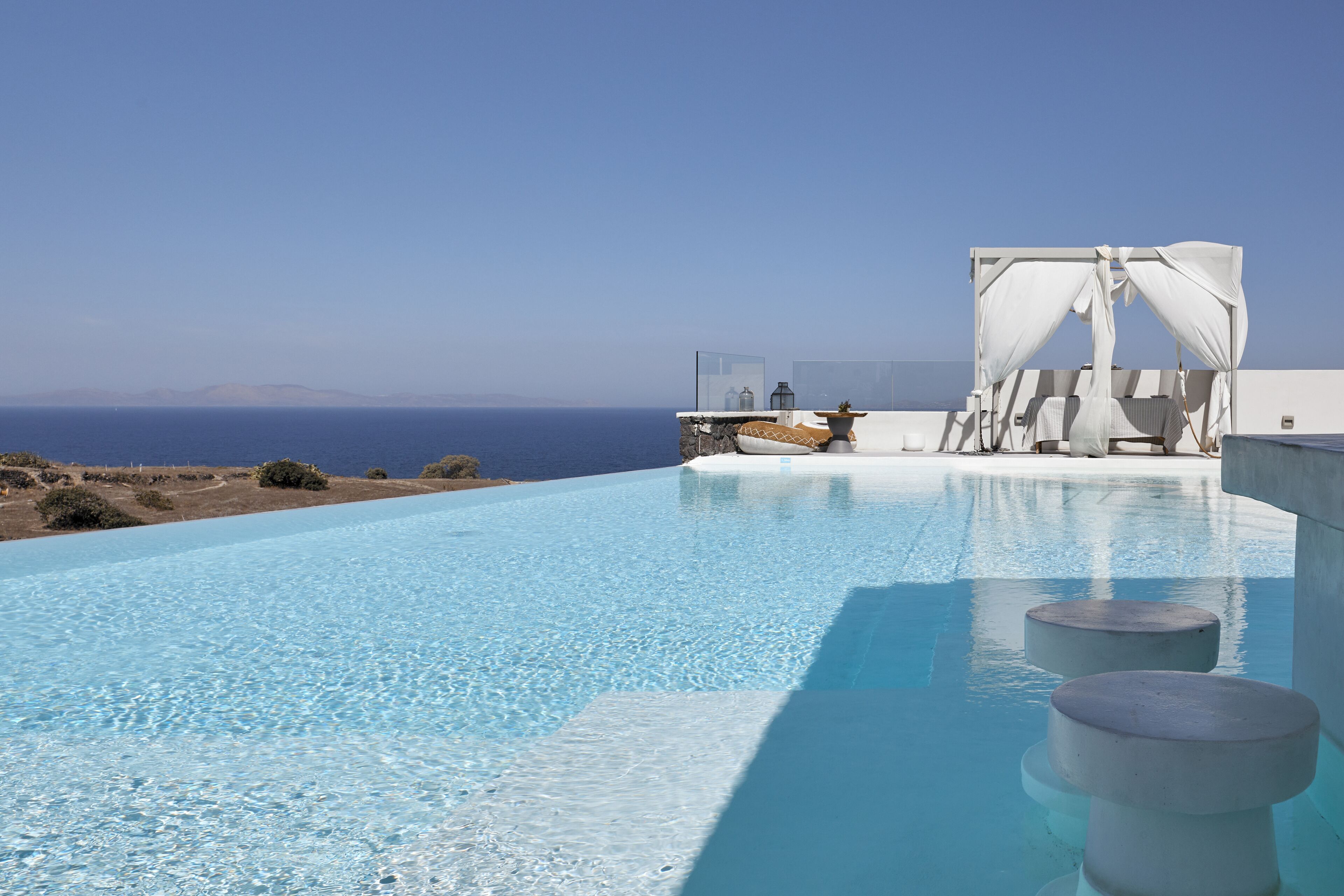 Ein klares, blaues Infinity-Pool mit Blick auf das Meer und ferne Berge.