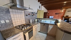 A modern kitchen with a gas stove, oven, dishwasher, and a marble countertop. - Renovated 4-Bedroom House near Loire Castles, Ideal for Families & Pros (Cléry-Saint-André)