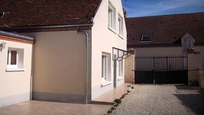 A two-story house with a tiled roof, a gravel driveway, and a gated entrance. - Renovated 4-Bedroom House near Loire Castles, Ideal for Families & Pros (Cléry-Saint-André)