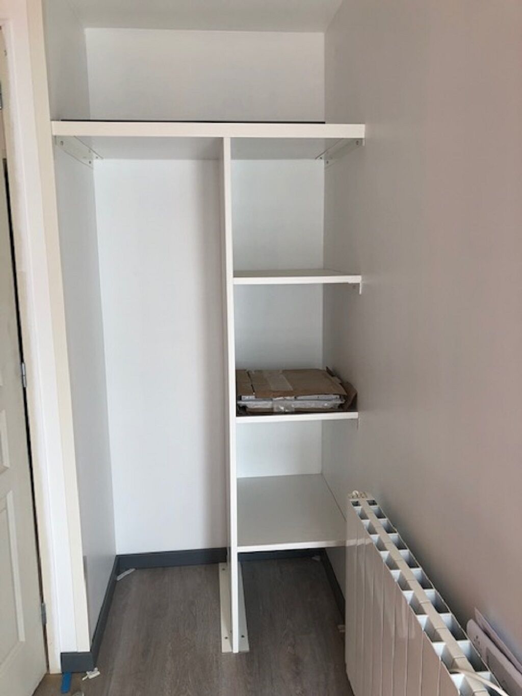 Vaatehuone, jossa on avohyllyjä ja patteri.