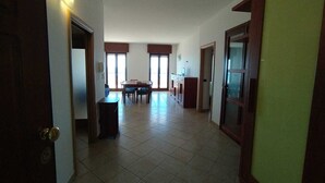 A spacious hallway with a dining area, a kitchen, and a large window providing natural light. - Rosa Virginia vista mare (Gallipoli)