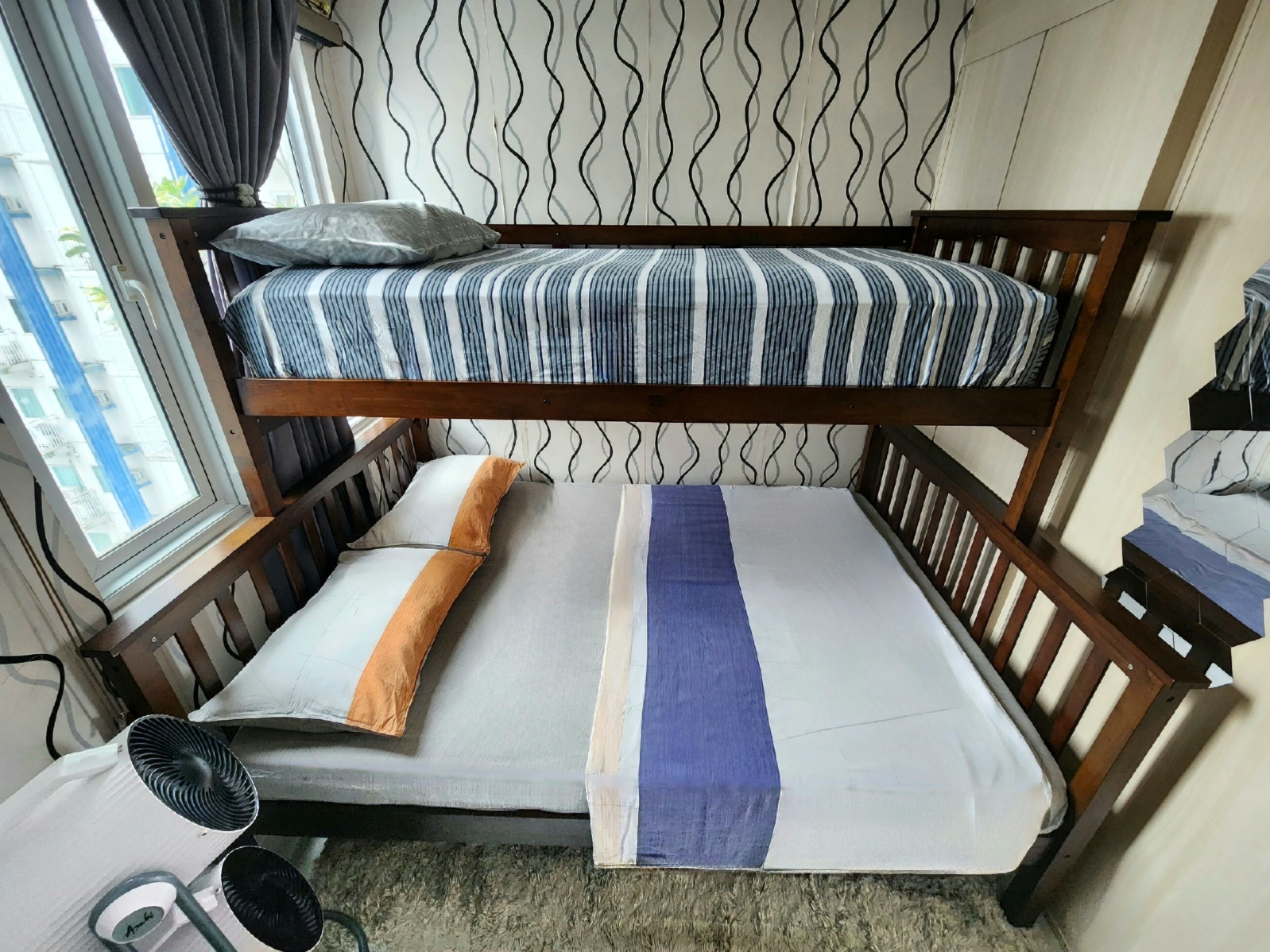 A bunk bed with striped bedding, a pillow, and a blanket.