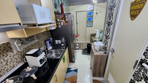 A compact kitchen with a microwave, coffee maker, and a refrigerator. - High-Tech Studio at Grass Residences -2 persons only, Quezon City (Quezon City)