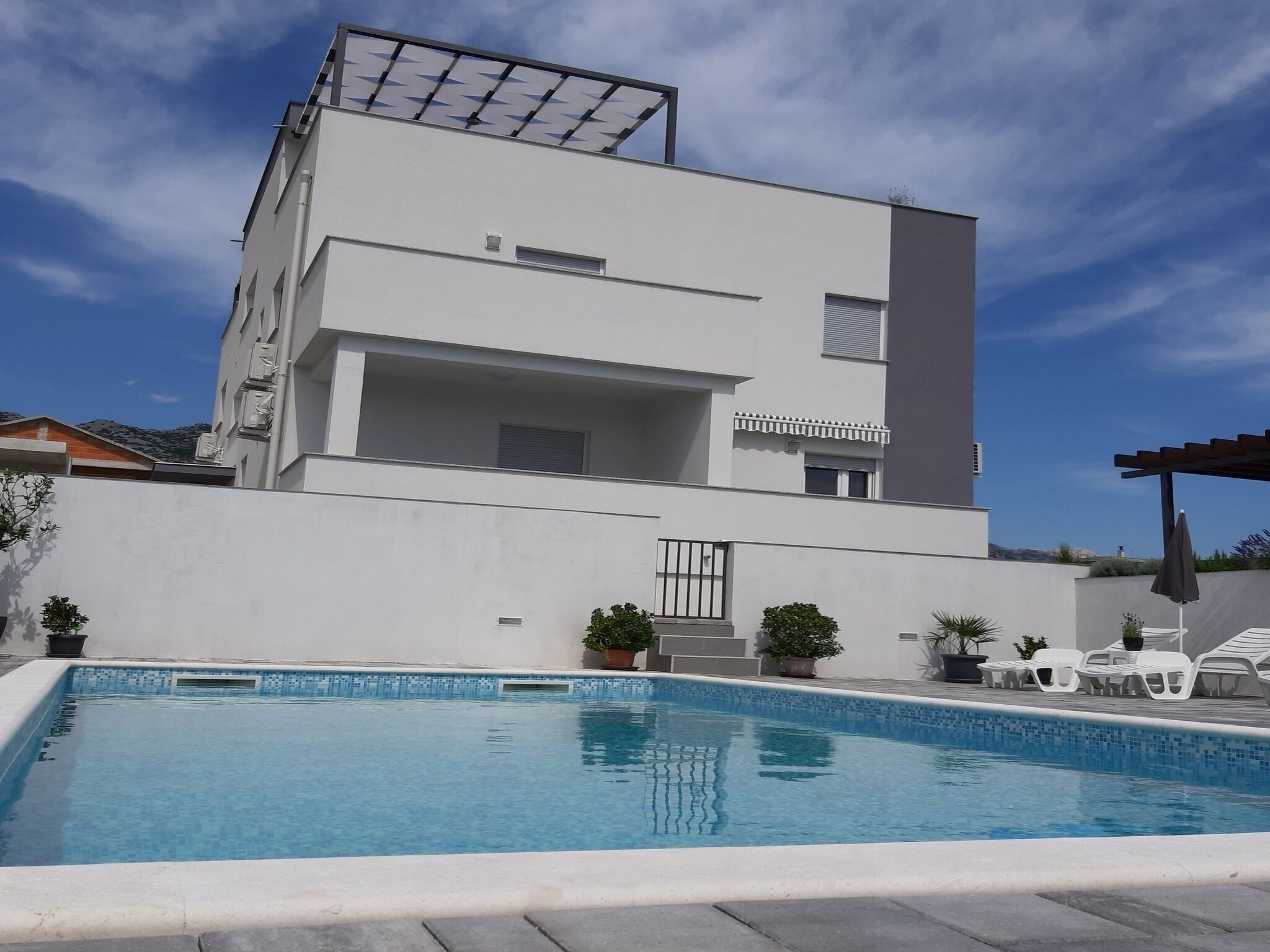 Ein modernes, zweistöckiges Gebäude mit einem Pool davor.