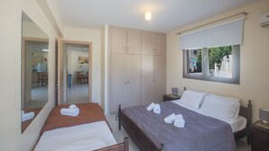 A bedroom with two beds, a wardrobe, a mirror, and a window with a view. - Apt. Suri, Modern 2BDR Apt. in the heart of Ayia Napa, Close to Nissi Avenue (Ayia Napa)
