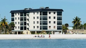A multi-story hotel with a flat roof, located adjacent to a beach. - Estero Sands Condo with 2 bedrooms and 2 baths (Fort Myers Beach)