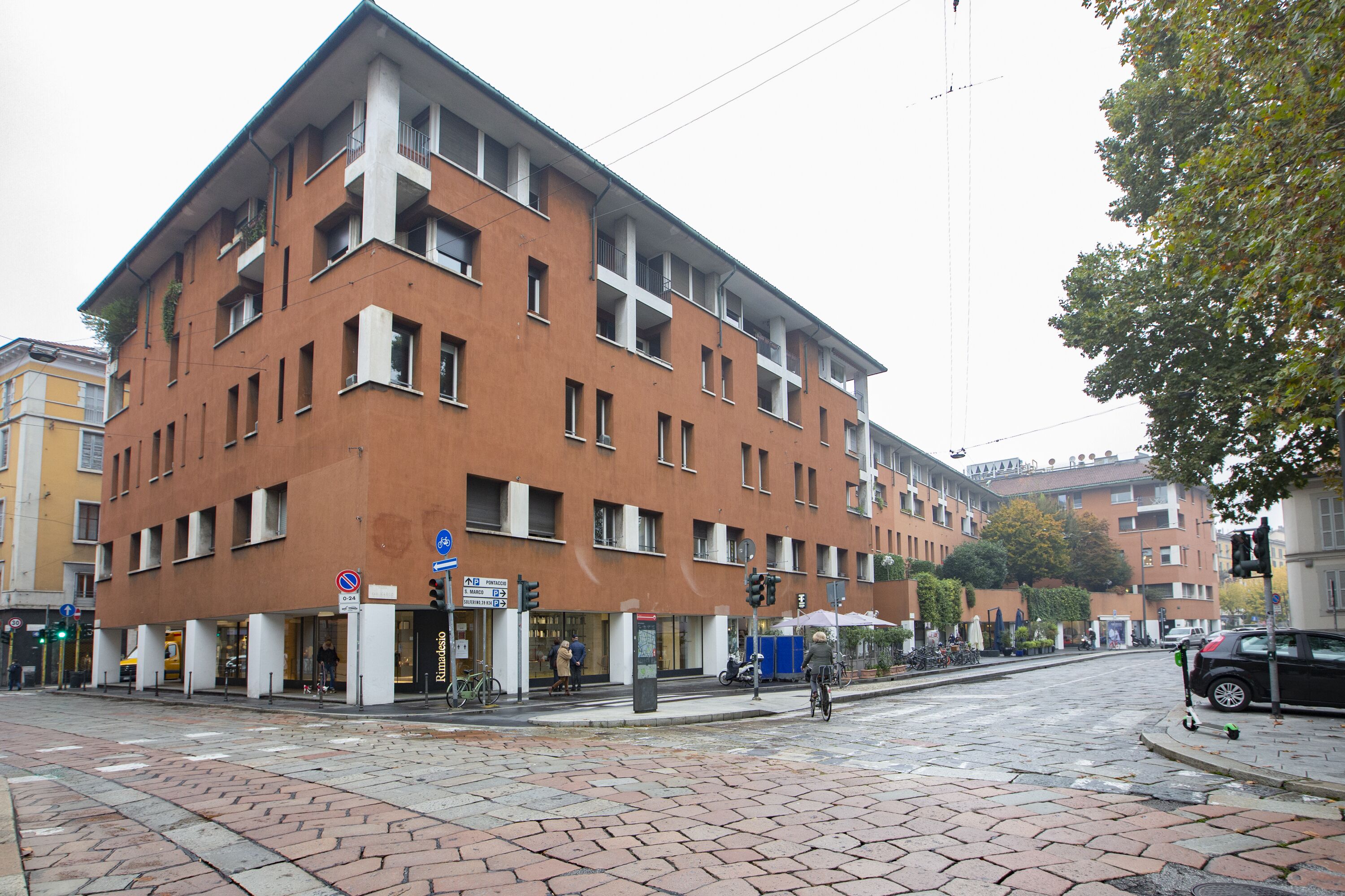 Un edificio de varios pisos con fachada de ladrillo, ventanas grandes y techo plano.