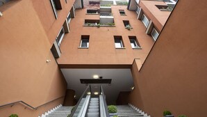 Un bâtiment moderne doté d’un escalier central et de nombreux balcons.