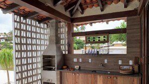 A kitchen with a wooden countertop, a built-in oven, and a window overlooking a residential area.
