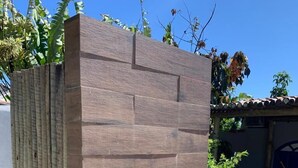 A modern outdoor pool area with a wooden structure and a water feature.