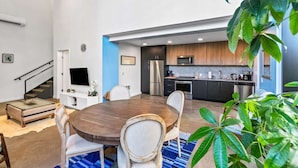 A modern kitchen with dark cabinets, stainless steel appliances, and a blue accent wall. - Elegant design meets optimal location amid the natural beauty of Downtown Redmond. (Redmond)