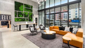 A modern interior with a seating area, a large window with a city view, and a green wall with foliage. - Elegant design meets optimal location amid the natural beauty of Downtown Redmond. (Redmond)
