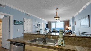 A kitchen with granite countertops, stainless steel appliances, and a view to the outside.