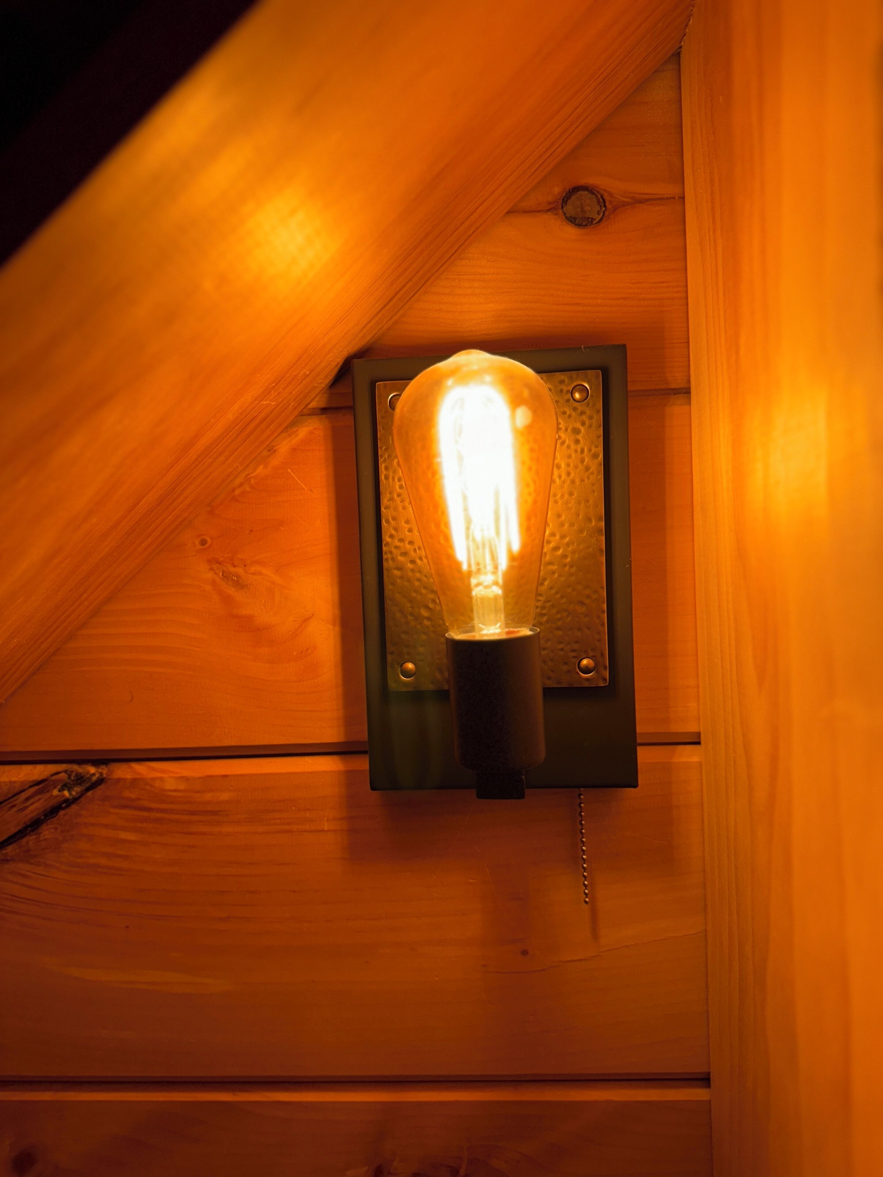 Un luminaire fixé sur un mur en bois.