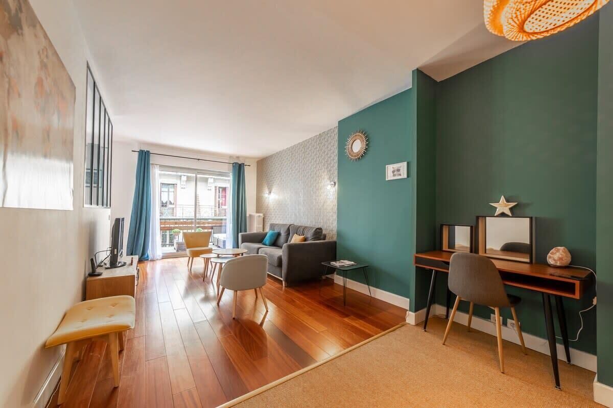 Een moderne woonkamer met een bank, salontafel en bureau met een computer.