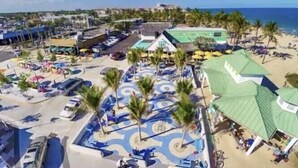 An aerial view of a resort with a pool area, palm trees, and beach access. - Beach Getaway, Cozy Studio Villa #2 (Lauderdale-by-the-Sea)
