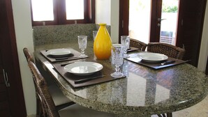 A dining table set with plates, cutlery, and a yellow vase. - Casa Barramares em Cotovelo com piscina (Parnamirim)