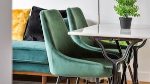 A modern living room with a green sofa, a white table, and a black floor lamp. - Neruda - Le 31 bis - Appt proche centre Rennes (Rennes)