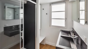 A modern bathroom with a glass shower enclosure, a large window, and a vanity with a sink. - Neruda - Le 31 bis - Appt proche centre Rennes (Rennes)