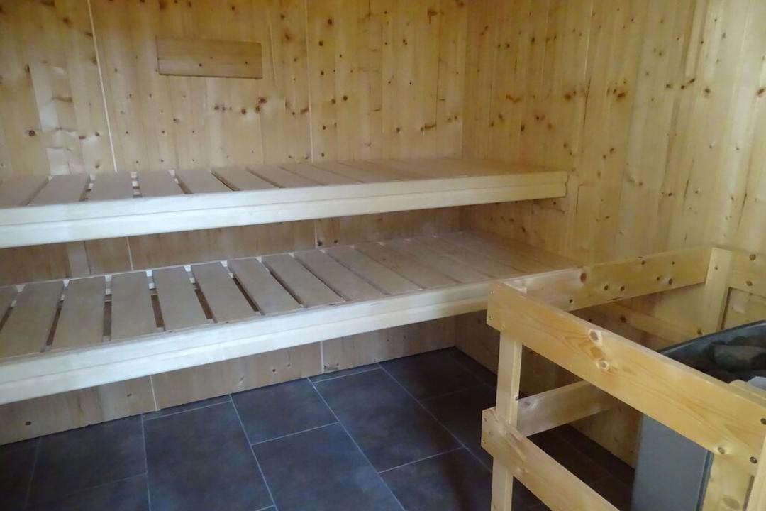 A sauna with wooden benches and a tiled floor.
