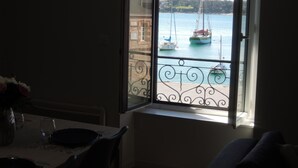 Ein Zimmer mit Fensterblick auf einen Hafen und Segelboote.