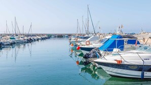 A marina with multiple boats docked in calm waters. - A&n   Seaport     1a (Caleta de velez)