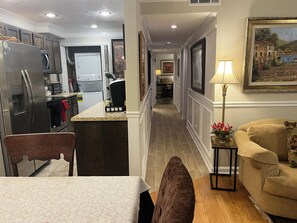 A kitchen with a refrigerator, stove, microwave, and a dining area with a table and chairs.