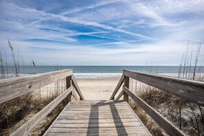 A wooden boardwalk leading to a beach with a clear sky. - Beach Chic Retreat! (Fernandina Beach)