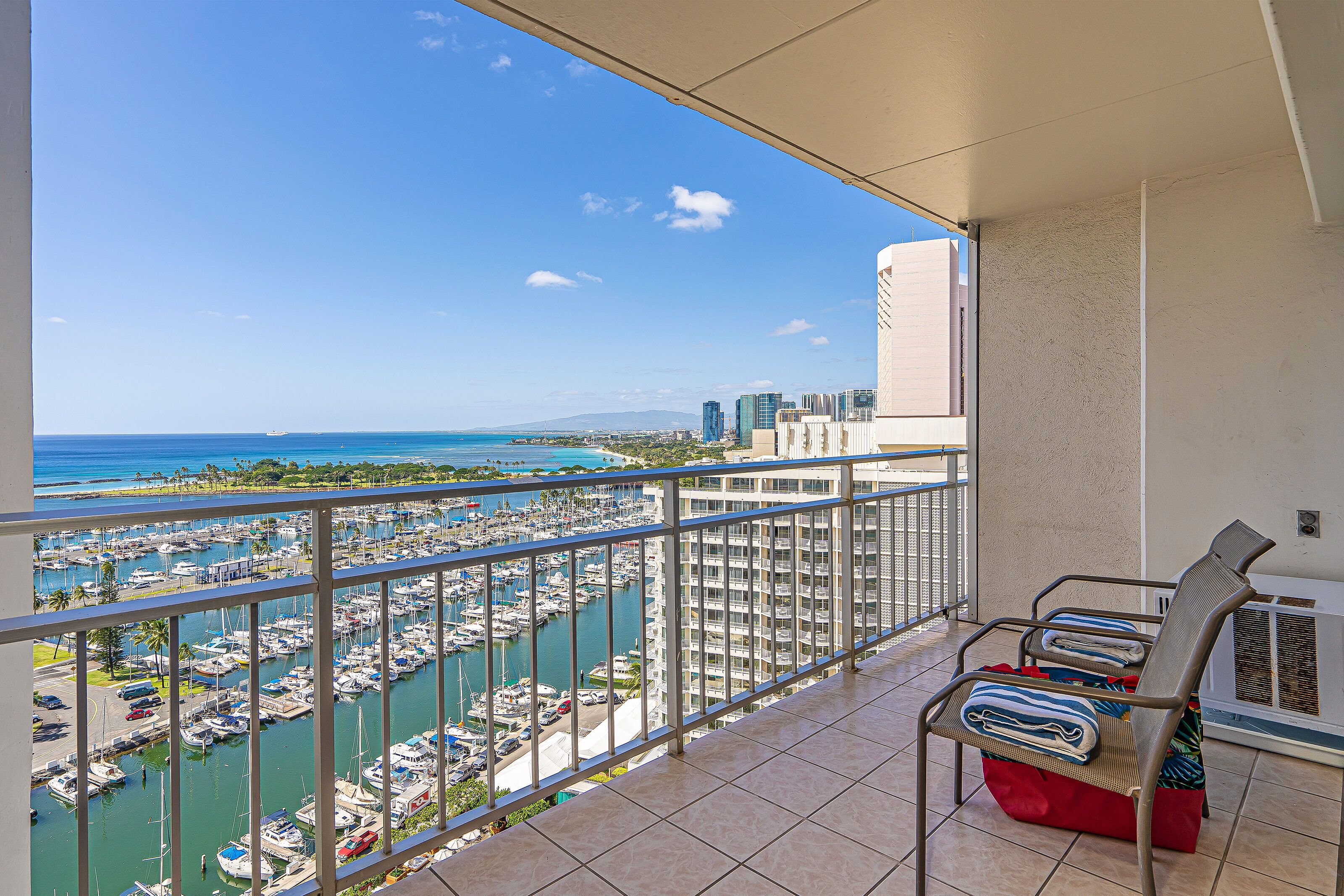 A balcony with a view of a marina and cityscape.